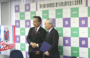 契約書に調印した堀達也札幌大学理事長(右)と、矢萩竹美北海道フットボールクラブ代表取締役社長