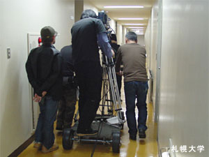 映画「壁男」の撮影が本学サークル会館で行われ、主演の小野真弓さんが来学しました。
